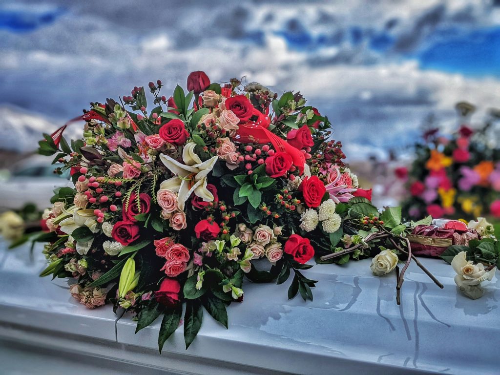 Blumendekoration auf einer Kirchenbank während einer Trauerfeier – Bestandteil des Bestattungsablaufs bei Wicky und Partner in Basel.